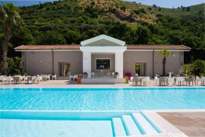a villa with a swimming pool in front of a mountain at Likò Resort in Nocera Inferiore