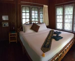 un grande letto bianco con un farfallino sopra di Koh Tao Royal Resort a Ko Tao