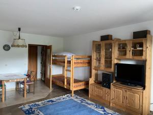 a room with bunk beds and a table and a television at Ferienwohnung Voges in Bad Lauterberg