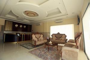 Al Dhiyafa Palace Hotel Apartments قصر الضيافة للشقق الفندقية في مسقط: غرفة معيشة مع كرسيين وطاولة