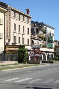 un edificio al lado de una calle con un cartel en B&B La Ruota Milano, en San Giuliano Milanese