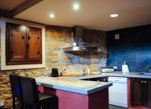 a kitchen with a counter and a stone wall at Casa Plaza de Culla in Culla