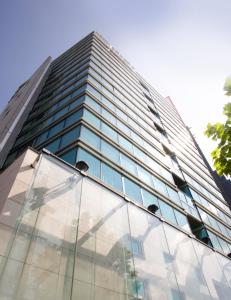 a tall building with glass windows on the side of it at HOTEL APERTO (Adult Only) in Tokyo