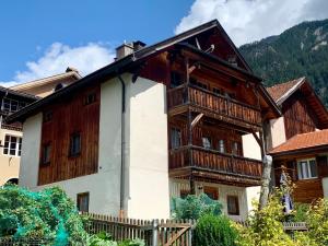 a wooden house with a balcony on the side of it at Tga Clavo in Filisur
