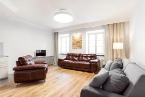 Twin apartments 3 Bedr by Reside Baltic في فيلنيوس: غرفة معيشة مع أريكة وأثاث من الجلد