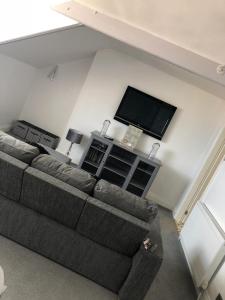 a living room with a couch and a flat screen tv at Bay View Apartment in Newbiggin-by-the-Sea