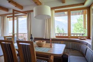 a dining room with a table and some windows at Apartments Vila Jelka in Bohinj