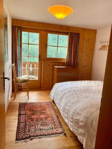 a bedroom with a bed and a chair and a window at Tga Clavo in Filisur