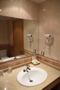 a bathroom with a sink and a large mirror at Hotel Restaurante Casa Pipo in Tuña