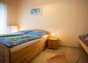 1 dormitorio con cama de madera y mesita de noche con lámpara en Ferienwohnung Haus Edelweiss en Winterberg