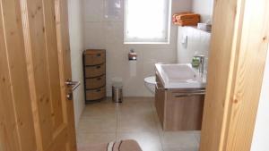 a bathroom with a sink and a toilet and a window at Ferienwohnung Haus Edelweiss in Winterberg +18 photos