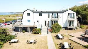 an aerial view of a white house with chairs at Vejby Strand Hotel in Vejbystrand