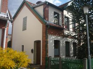 ein weißes Haus mit einem Zaun und einem Straßenlicht in der Unterkunft Ferienwohnung Berta Lüneburg in Lüneburg