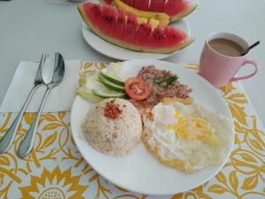 un plato de comida con huevos y arroz y una taza de café en ARAMARA Resort en Panglao