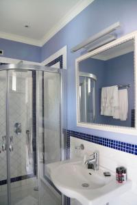 a blue bathroom with a sink and a shower at Hotel Mea - Aeolian Charme in Lipari