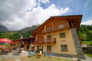 un grande edificio in legno con balcone e sedie di Walsertal Residence a Gressoney-la-Trinité