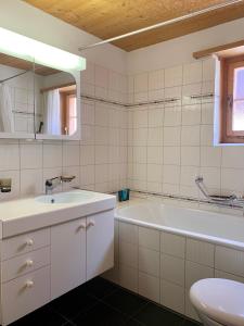 a bathroom with a tub and a sink and a toilet at Tga Clavo in Filisur