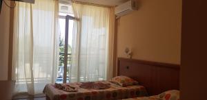 a bedroom with a bed and a large window at DSK Hotel in Kranevo +40 photos