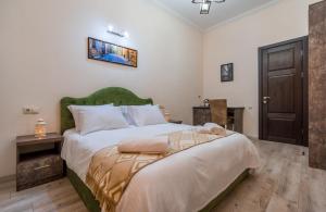 um quarto com uma cama grande e uma cabeceira verde em Golden Light Hotel em Tbilisi