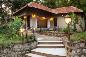 a house with two lights and stairs in front of it at Old Kent Estates & Spa, Coorg in Suntikoppa