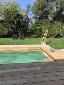 uma piscina com um deque de madeira e um quintal em Guest House Olivades em Cassis