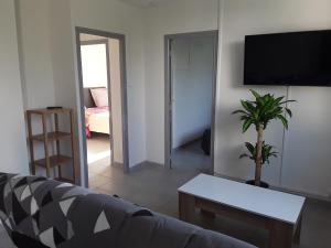 ein Wohnzimmer mit einem Sofa und einem TV in der Unterkunft La villa in Le Vigan