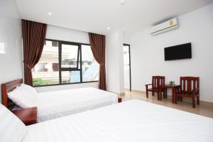 Habitación de hotel con 2 camas y TV en Thanh Tu Hotel, en Cửa Lô