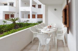 einen weißen Balkon mit einem weißen Tisch und Stühlen in der Unterkunft Secreto in Oliva
