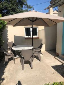 einen Tisch und Stühle unter einem Sonnenschirm auf einer Terrasse in der Unterkunft La villa in Le Vigan