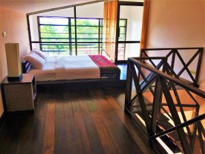 a bedroom with a bed and a large window at Chor Chang Villa Resort in Choeng Mon Beach