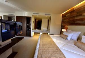 ein Hotelzimmer mit einem großen Bett und einem Flachbild-TV in der Unterkunft BUSINESS HOTEL SFAX in Sfax