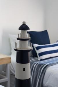 a black and white lighthouse sitting next to a bed at Anchor Guesthouse in Secunda