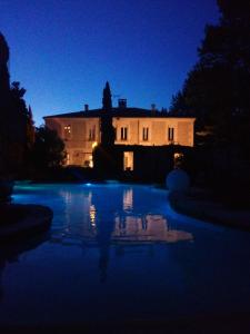 ein Haus in der Nacht mit Pool vor einem Haus in der Unterkunft Auberge Du Parc in Orgon