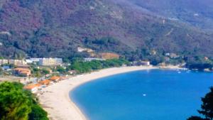 a view of a beach with blue water and mountains at U Palmu in Sagone +5 photos