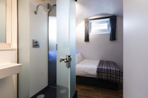 a small room with a small bed and a door at CoDE Pod – The CoURT - Edinburgh in Edinburgh