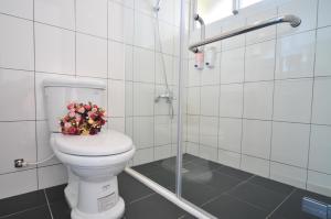 a bathroom with a toilet with a bouquet of flowers on it at Full Sun House - Peng's Family in Taitung City