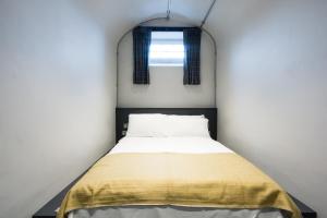 a bed in a small room with a window at CoDE Pod – The CoURT - Edinburgh in Edinburgh