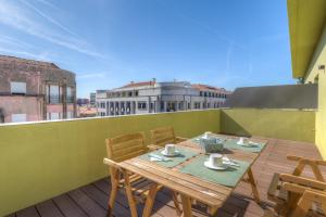 a wooden table and chairs on a balcony at Spot Family Apartments in Porto