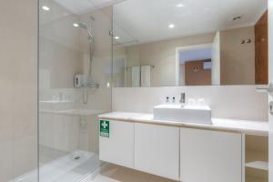 uma casa de banho branca com um lavatório e um chuveiro em Spot Family Apartments no Porto