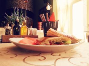 un plato de comida con un sándwich en una mesa en Bed & Breakfast Twenty, en Kikinda