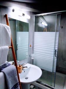 a bathroom with a sink and a glass shower at Nouvelle in Oraiokastro