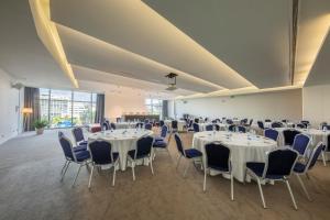 um salão de banquetes com mesas brancas e cadeiras azuis em Meliá Maputo Sky em Maputo