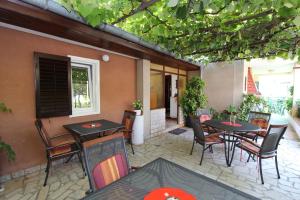 un patio avec des tables et des chaises et un bâtiment dans l'établissement Rooms And Apartment Pina, à Rovinj