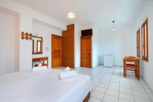 a bedroom with two beds and a desk in it at Komninos Rooms in Panagia