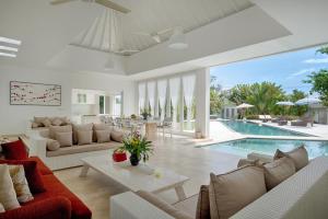 a living room with a pool and a villa at Kutus Kutus Canggu Villa in Canggu