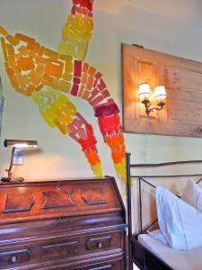 a stained glass giraffe on a wall next to a bed at Kornspeicher Himmelpfort in Himmelpfort