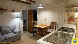 a kitchen with a sink and a table and a couch at Camping Yoghi e Bubu in San Giacomo