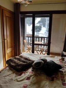 a bedroom with a bed with a view of a balcony at Soldeu Paradis Tarter Alt in Canillo