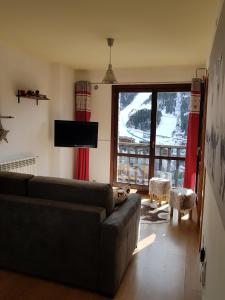 a living room with a couch and a large window at Soldeu Paradis Tarter Alt in Canillo