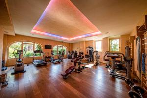 a gym with lots of exercise equipment in a room at L'Andana Tenuta La Badiola in Castiglione della Pescaia